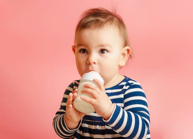cute baby drinking milk from a bottle